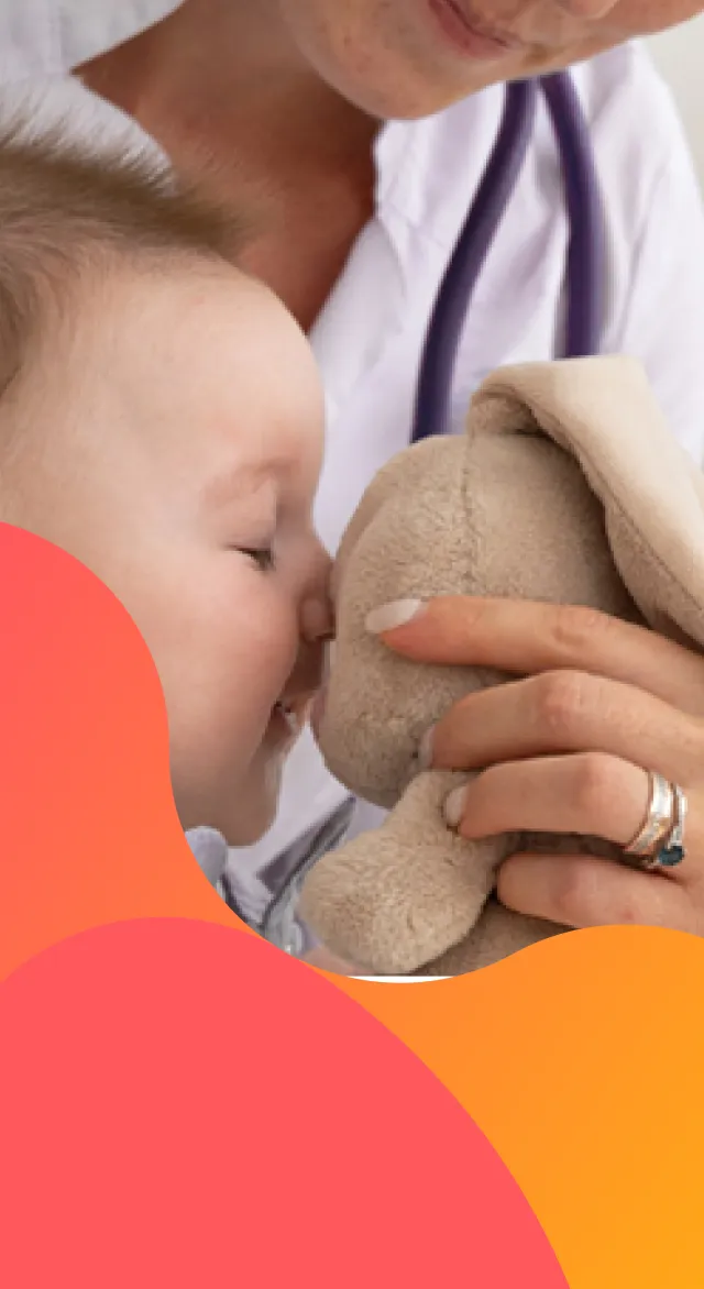 Bebé jugando con un peluche con una doctora