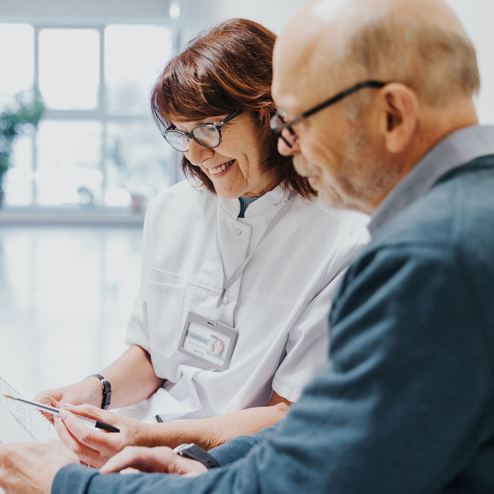 Ärztin erklärt einem Patienten die Befunde