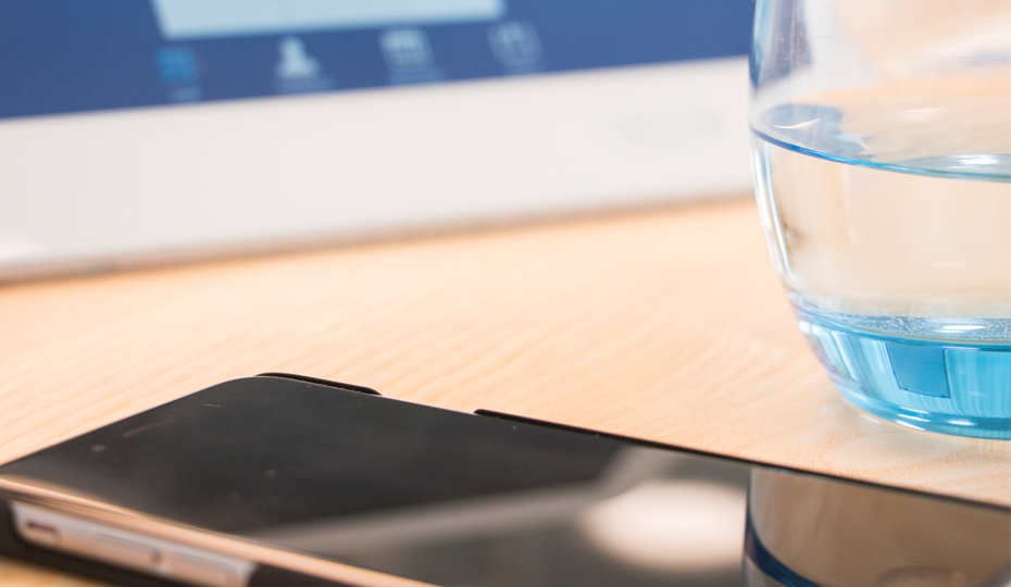 Tablet, Mobiltelefon und ein Glas Wasser