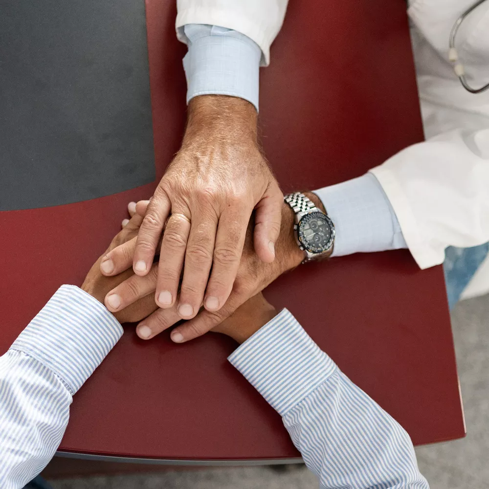 Arzt hält die Hände eines Patienten