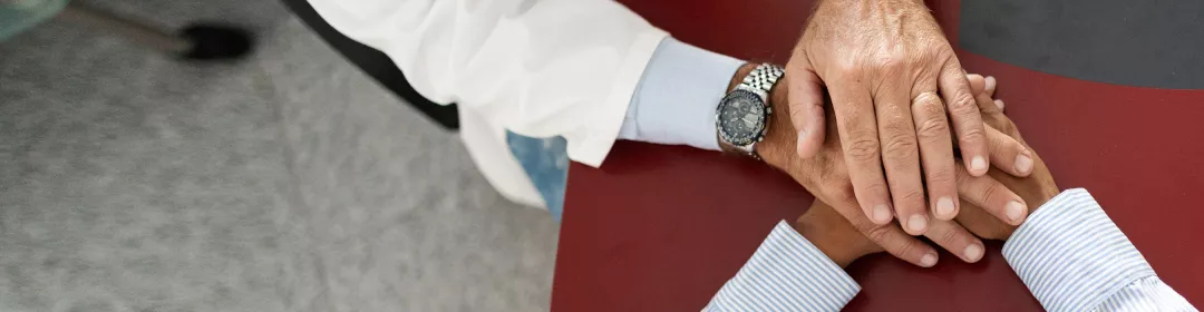 Arzt hält die Hände ines Patienten