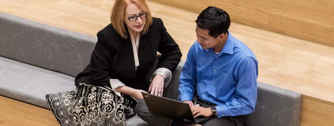 Zwei Personen gucken gemeinsam auf einen Bildschirm