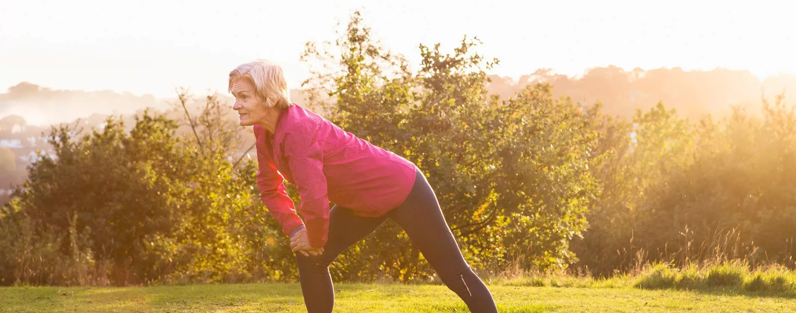 Older woman stretching in nature Older woman stretching in nature