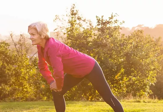 Older woman stretching in a park