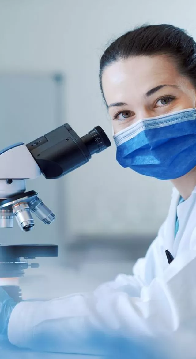 Médica con un microscopio