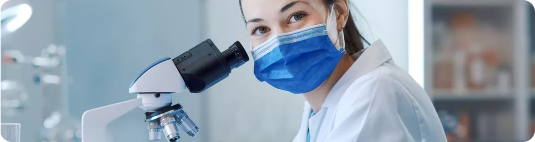 Médica con un microscopio