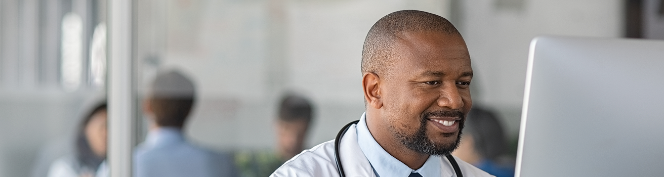 Doctor sonriendo frente una pantalla