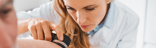 Una mujer examina el brazo de un hombre