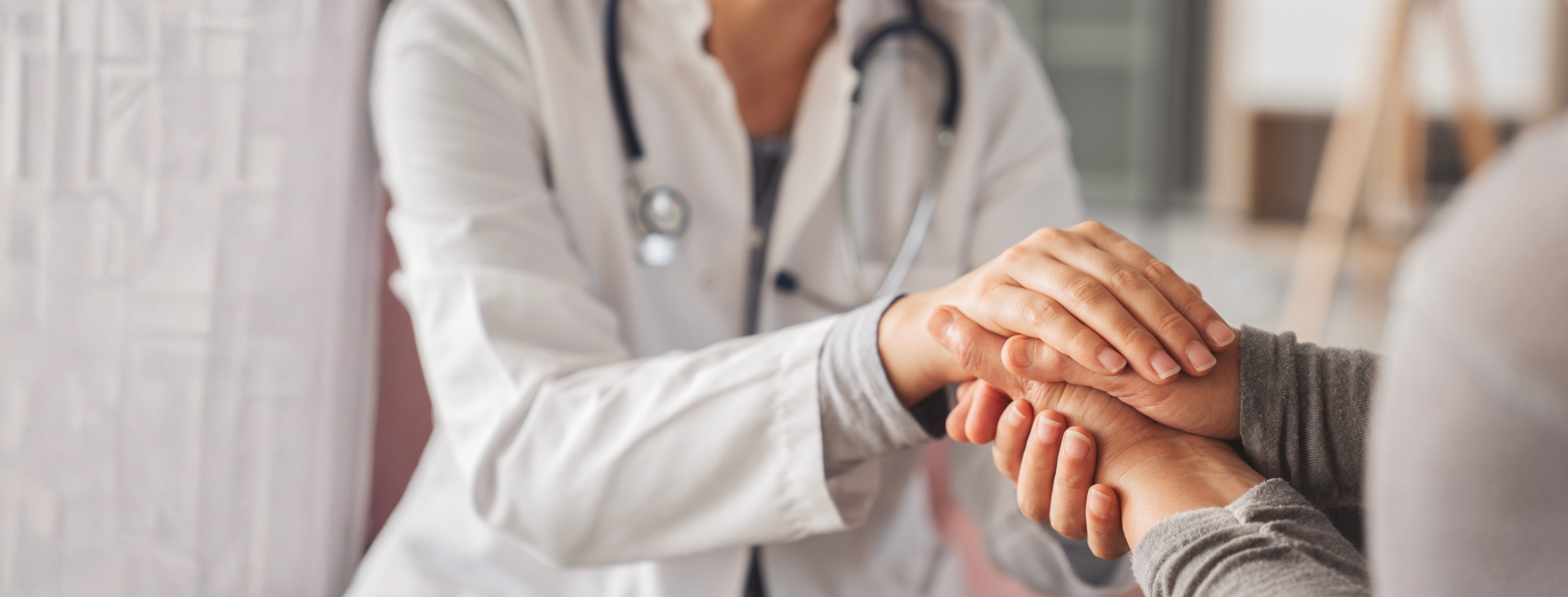 Un doctor y un paciente se toman de las manos