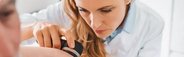 Una mujer examina el brazo de un hombre