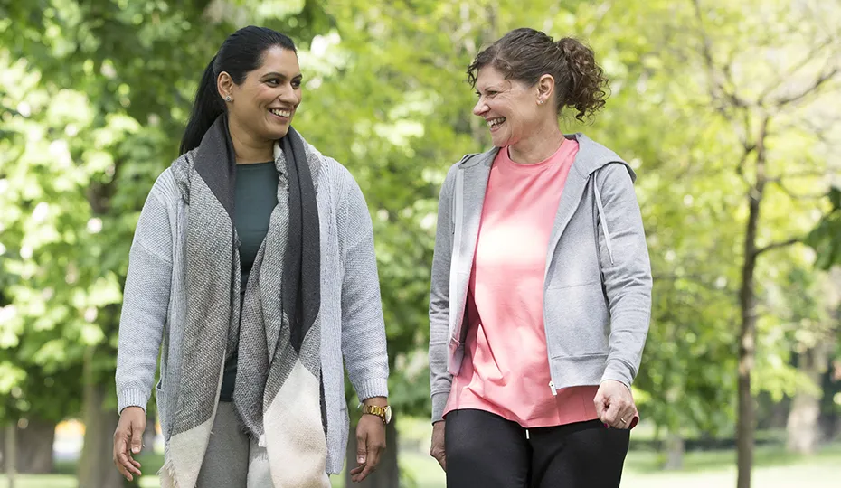 Image of two women walking in a park.